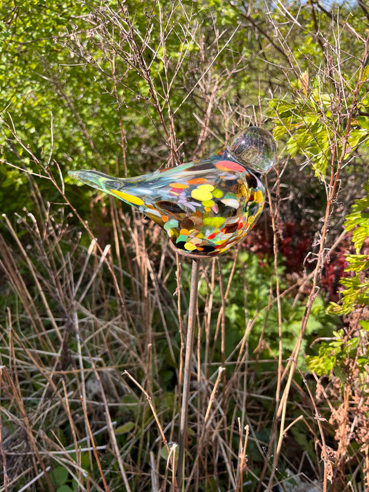 Harlekin farvet glas fugl på pind.