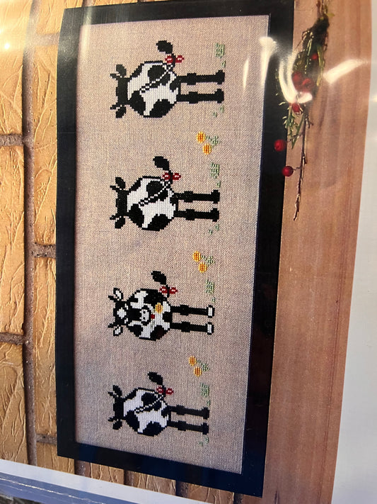 Broderi kit køer på række.