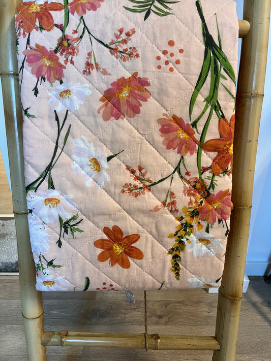 Quiltet plaid rosa med blomster.